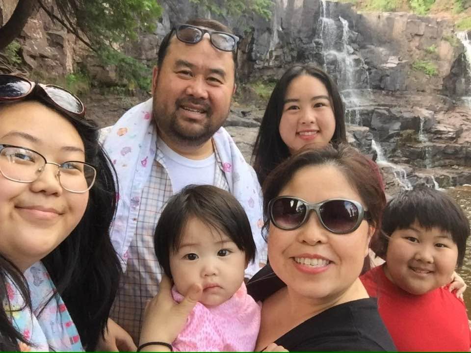 The Vang family together in front of a waterfall